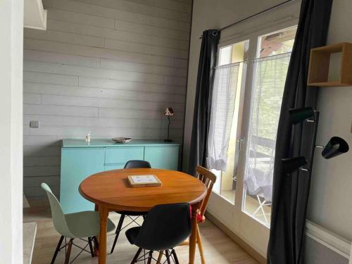 een eetkamer met een tafel en stoelen en een raam bij Appartement charmant - Allos in Allos