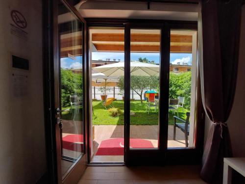 an open door to a patio with an umbrella at Pizzocolo resort fasano in Gardone Riviera