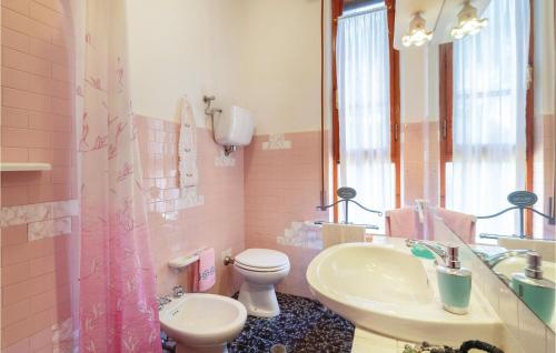 uma casa de banho rosa com um lavatório e um WC em Aurora em Piana