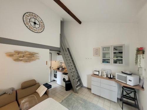 un salon avec un canapé et une horloge au mur dans l'établissement Maison tout confort à la mer 200m de la plage, 2 chambres, 2min Royan, à Saint-Georges-de-Didonne
