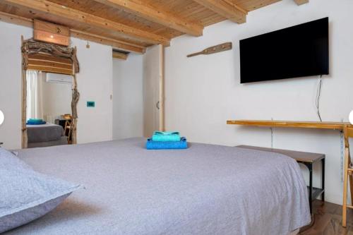 a bedroom with a bed and a flat screen tv at B&B Diec10 in Murta Maria