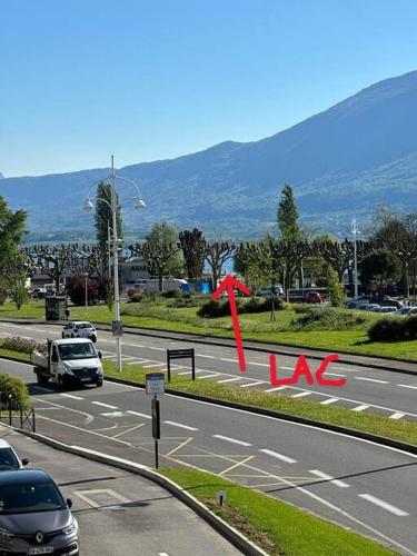 une route avec des voitures et une flèche rouge sur la route dans l'établissement Aix les Bains Bel appartement 3 pièces face au lac, à Aix-les-Bains