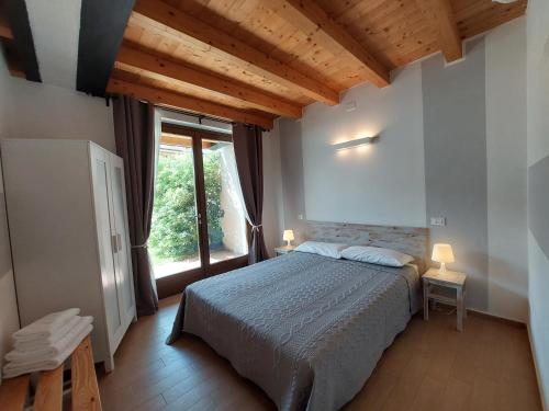 a bedroom with a bed and a large window at Pizzocolo resort fasano in Gardone Riviera