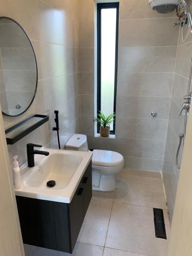 W łazience znajduje się umywalka, toaleta i lustro. w obiekcie شاليه اوبل قاردن - OPAL GARDENS w mieście Al-Baha