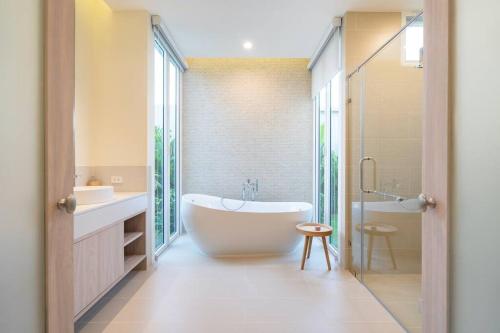 a bathroom with a tub and a sink and a shower at Peykaa Estate Pool Villa by HCR in Phuket Town
