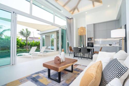a living room with a white couch and a table at Peykaa Estate Pool Villa by HCR in Phuket Town