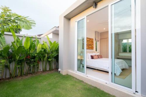 a bedroom in a house with a garden at Peykaa Estate Pool Villa by HCR in Phuket Town
