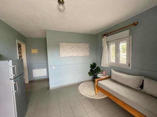a living room with a couch and a window at Palatino in Afitos