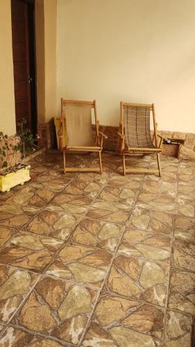 twee stoelen in een kamer met een stenen vloer bij Casa Completa com 03 quartos a um quarteirão da Basílica Nacional in Aparecida