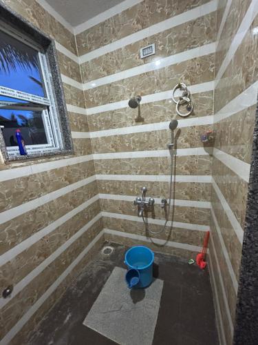 baño con ducha y cubo azul en Kashi Farm House, en Channarāyapatna
