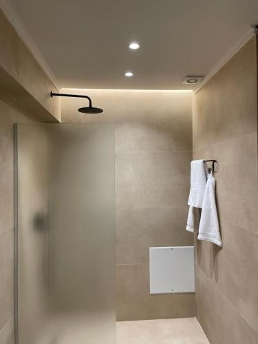baño con ducha y toalla colgada en la pared en La Grand - New Bazaar, en Tirana