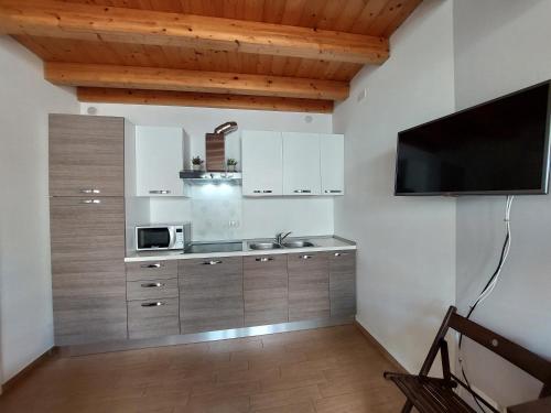 a kitchen with a sink and a microwave at Pizzocolo resort fasano in Gardone Riviera