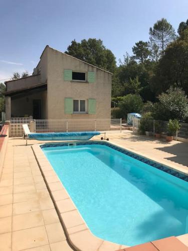 une grande piscine devant un immeuble dans l'établissement Belle Villa provençale avec piscine à Brignoles, à Brignoles