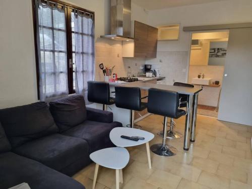 un salon avec un canapé et une cuisine dans l'établissement appartement en rez de jardin, à Foce