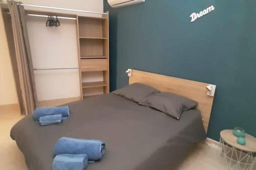 - une chambre avec un grand lit et deux tabourets bleus dans l'établissement appartement en rez de jardin, à Foce