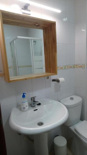 ein Badezimmer mit einem weißen Waschbecken und einem WC in der Unterkunft TourismCasa in Dos Hermanas