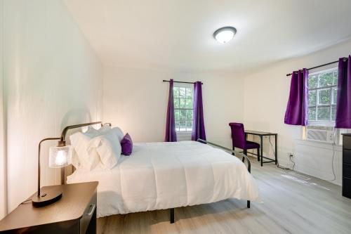 a bedroom with a white bed and purple curtains at Winston-Salem Vacation Rental about 3 Mi to Downtown! in Winston-Salem