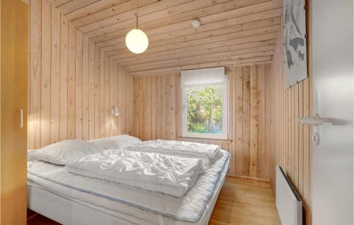 Nørre VorupørにあるAwesome Home In Thisted With 3 Bedrooms And Saunaの窓付きの木造の部屋のベッド1台