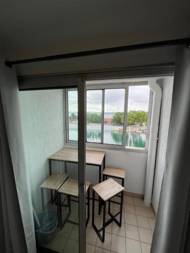 une chambre avec une table, des bancs et une fenêtre dans l'établissement Séte 6eme vue sur le canal et l'étang, à Sète