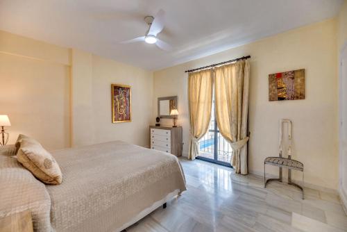 een slaapkamer met een bed en een raam bij Puerto Banus3 Sandy Beachside in Marbella