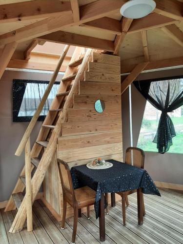 a dining room with a table and a staircase at A l'aube des sens in Bailly-le-Franc