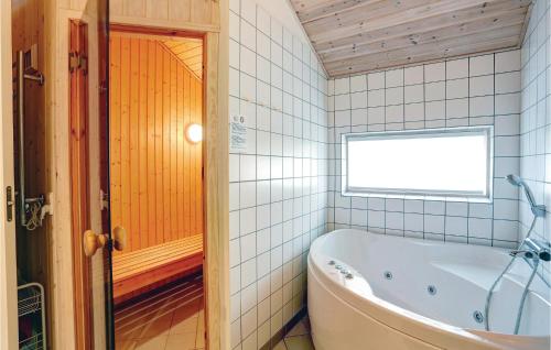 SnogebækにあるAwesome Home In Nex With 4 Bedrooms, Sauna And Wifiのバスルーム(バスタブ付)、窓が備わります。