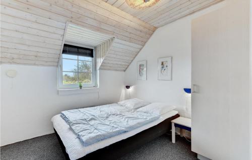 a white bedroom with a bed and a window at Nice Home In Ringkbing With 6 Bedrooms, Wifi And Indoor Swimming Pool in Søndervig