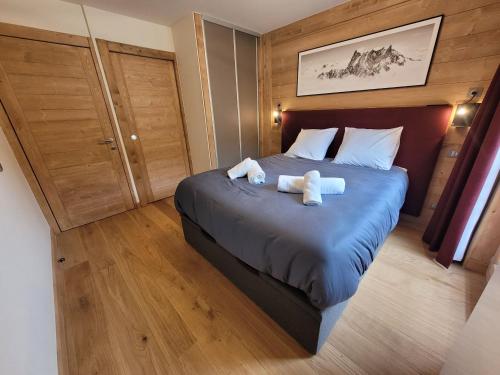 une chambre avec un lit avec deux ours en peluche dessus dans l'établissement Appartement 6 pers avec terrasse au cœur du village, résidence neuve avec sauna et parking - FR-1-598-141, aux Gets