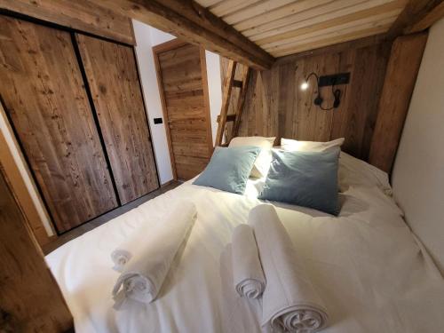 une chambre avec un lit blanc avec des serviettes dessus dans l'établissement Appartement de charme 4 pers, cœur de village, proche pistes - FR-1-598-142, aux Gets