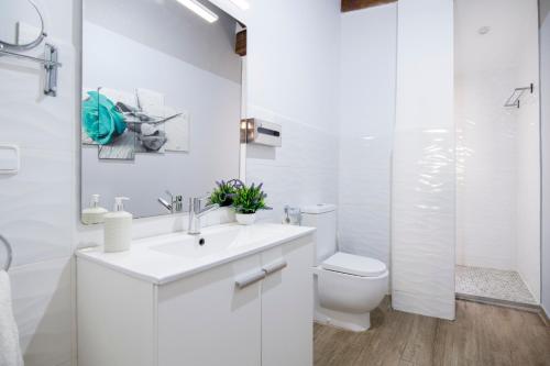 a white bathroom with a toilet and a sink at Cozy Duplex Apartment 1 step to City Center SelfCheckin! in Valencia