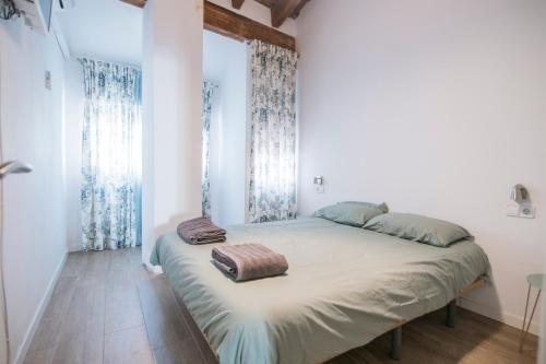 a bedroom with a bed with two pillows on it at Cozy Duplex Apartment 1 step to City Center SelfCheckin! in Valencia