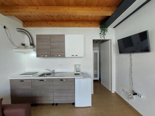 a kitchen with a sink and a refrigerator at Pizzocolo resort fasano in Gardone Riviera
