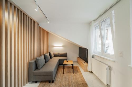uma sala de estar com um sofá e uma televisão em Zeus Design Apartmenthaus em Viena