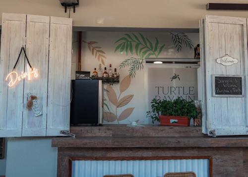 a restaurant with a counter with a window with plants at Turtle Bay Inn in Lajas