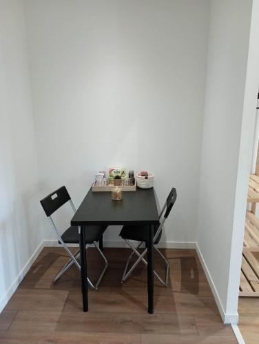une table noire et deux chaises dans une pièce dans l'établissement Chambre d'hôtes dans maison charentaise, à Mortiers