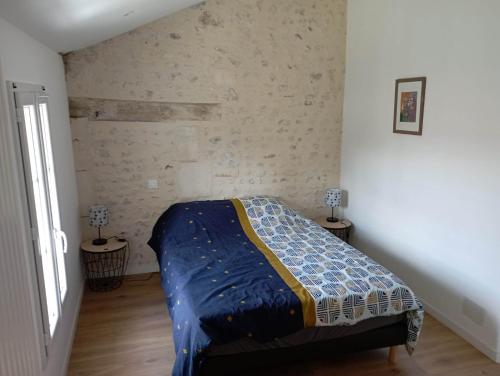 ein Schlafzimmer mit einem Bett in der Ecke eines Zimmers in der Unterkunft Chambre d'hôtes dans maison charentaise in Mortiers