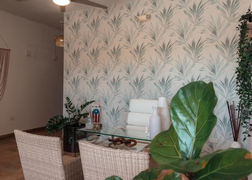 a living room with a table with chairs and a wallpaper at Turtle Bay Inn in Lajas