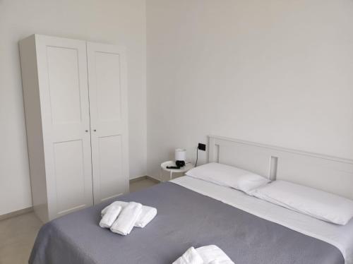 een witte slaapkamer met een bed met handdoeken erop bij Villa Rita in Fontane Bianche