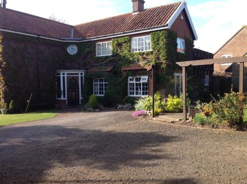 a brick house with a driveway in front of it at The Summer Room in Norwich