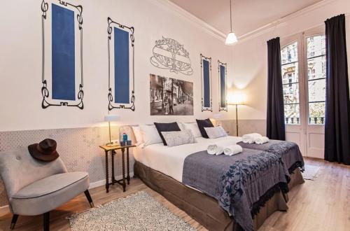 a bedroom with a bed and a chair and windows at Sweet Inn - La Pedrera - Paseo de Gracia in Barcelona