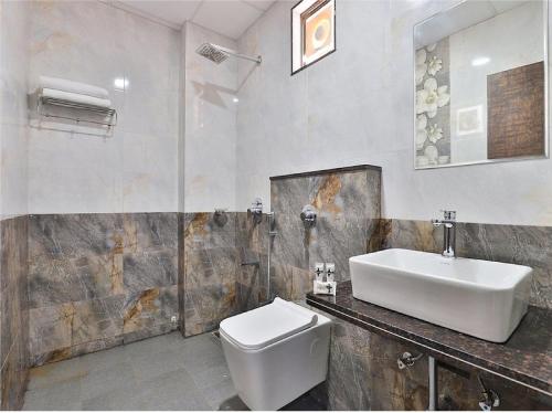y baño con lavabo y aseo. en The Sky Comfort Hotel Parth Inn, en Dwarka