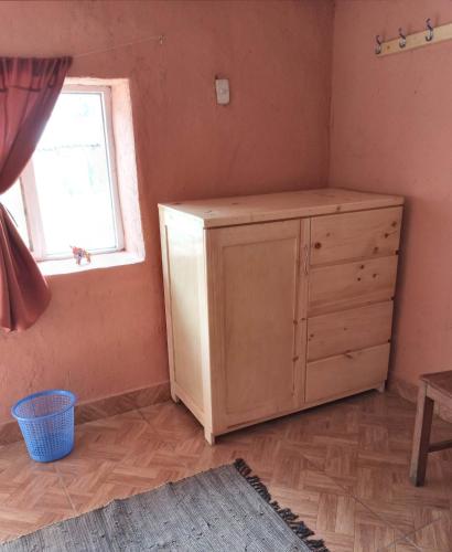 a room with a wooden dresser and a window at Wayqi Wasi in Pisac