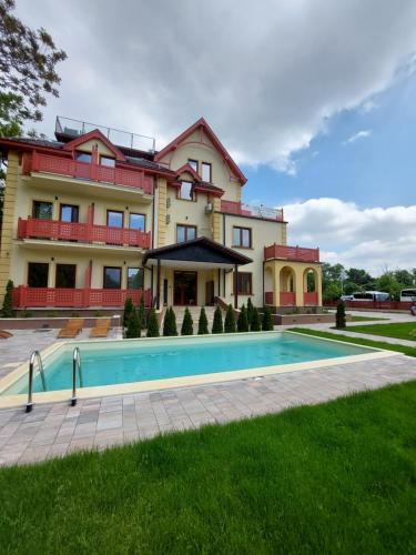 a house with a swimming pool in front of it at TORRO LUX Apartment in Palić