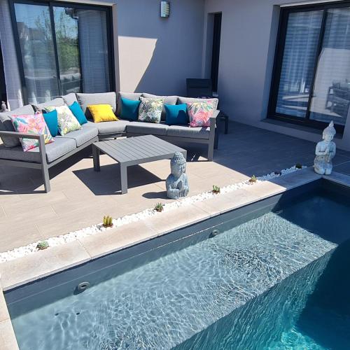 - un salon avec un canapé et une piscine dans l'établissement Villa- suite privée avec accès sur piscine, à Villebrumier