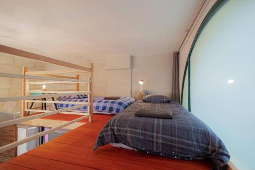 een slaapkamer met 2 stapelbedden en een trap bij Mini Loft 4 P, centre historique in Bordeaux