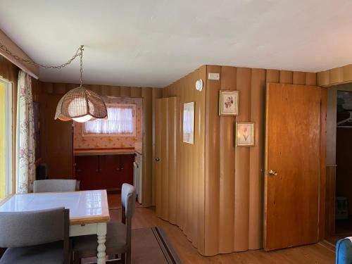 a dining room with a table and a room with a door at Amber Lantern One-Bedroom Cottage in Lake George
