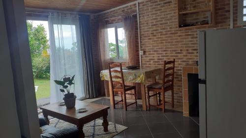 una cucina con tavolo e sedie e una sala da pranzo di Leu Océans a Saint-Leu
