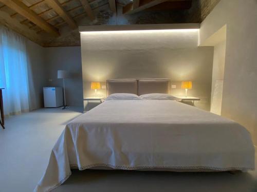 a bedroom with a large white bed with two tables at Piccola Dimora Gherardini in SantʼElpidio a Mare