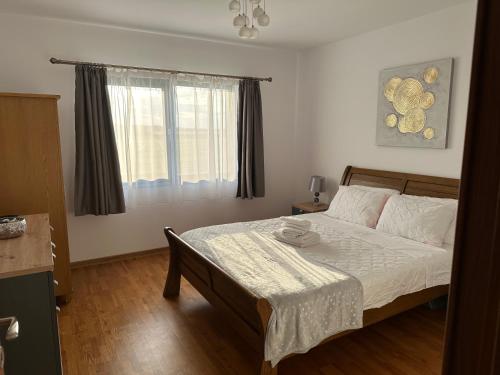 a bedroom with a bed and a window at Apartment la mare in Agigea