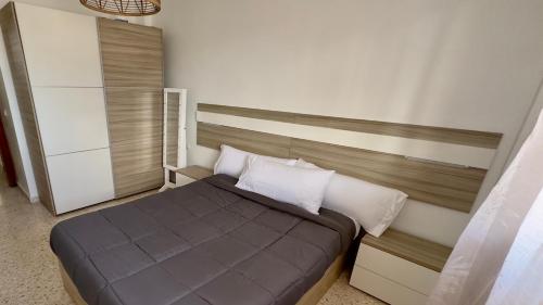 1 dormitorio con 1 cama con cabecero marrón y almohadas blancas en Primera línea de playa y Gibraltar a 5 minutos, en La Línea de la Concepción